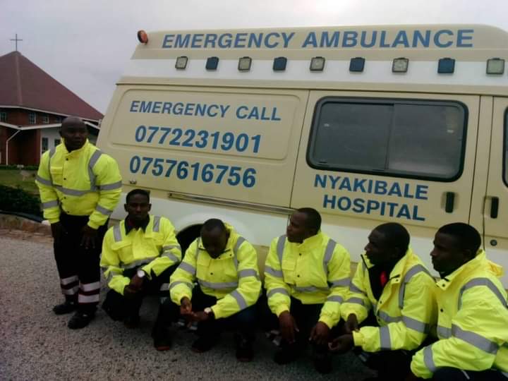 Das Rettungsteam des Nyakibale Hospital in Warnjacken vor seinem Krankenwagen.